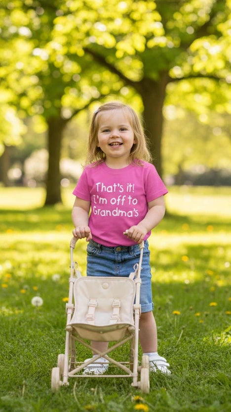 Child in a pink shirt with a stroller in a park